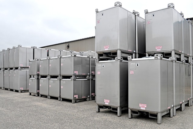 Parc de IBC tote tanks acier empilés en entrepôt — SCDQ reconditionnement